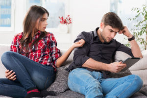 Woman thinking how to make him interested again as she taps him on the shoulder
